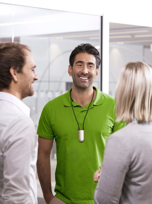 Phonak Roger Neckloop Universal Receiver 056-4005-P5111 used in the workplace.  Man in a green shirt wears the Phonak Roger Neckloop around his  neck while speaking to co-workers. 
