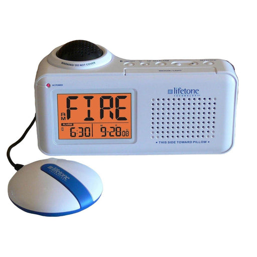 Lifetone Vibrating Fire Alarm and Clock HLAC151 on a white background. Alarm device with the word FIRE displayed on the screen along with the time and date.  A bed shaker disc is also shown.