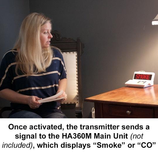 A woman sits in a chair beside the Sonic Alert HomeAware Main unit that displays the word SMOKE in red on the black screen.  Words printed under the photo read, "Once activated, the transmitter sends a signal to the HA360M Main Unit (not included), which displays "Smoke" or "CO". "
