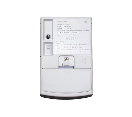 Back side of the Sonic Alert HomeAware Smoke & CO Sound Signaler HA360SSSCK2-1.  The black Link button and the Sensitivity Level switch is located above the batter back up door.